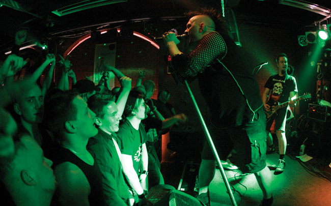 Tiivistä tunnelmaa
House of Rock, Kouvola 2007.
Avainsanat: Klamydia Vesa Jokinen House of Rock Kouvola verkkopaita mohikaani yleisö huutaa mikrofoniteline Jari Helin tiivis tunnelma ahdasta täynnä eturivi